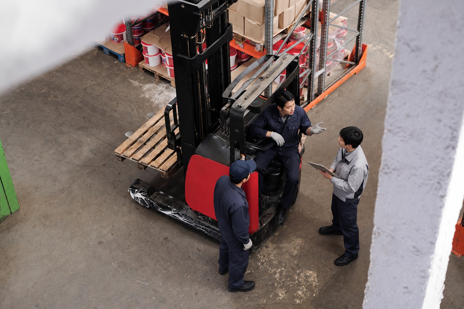 フォークリフトのそばで作業を確認する日本人男性スタッフ